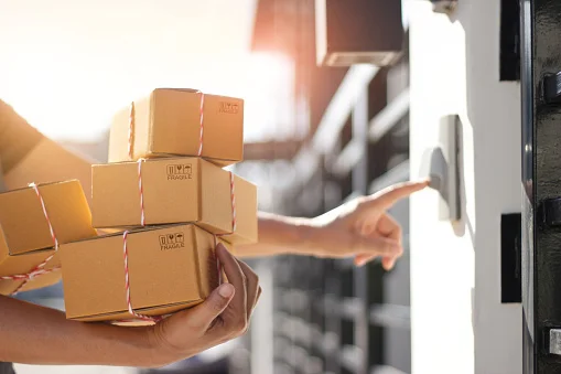Delivery professional holding parcel boxes at client's door
